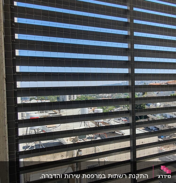 רשת מתכת על חלון למניעת כניסת יונים